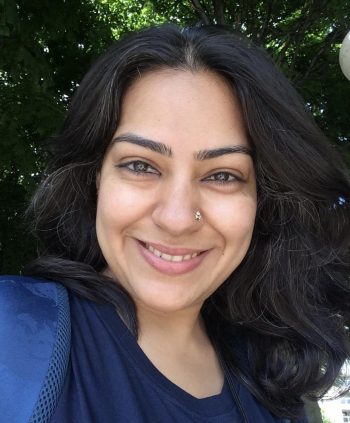 portrait of Sukruti Tirupattur, long black hair, a big smile in front of a tree